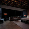 Interior view of a modern bedroom with a large bed, dark furniture, and an ornate ceiling design.