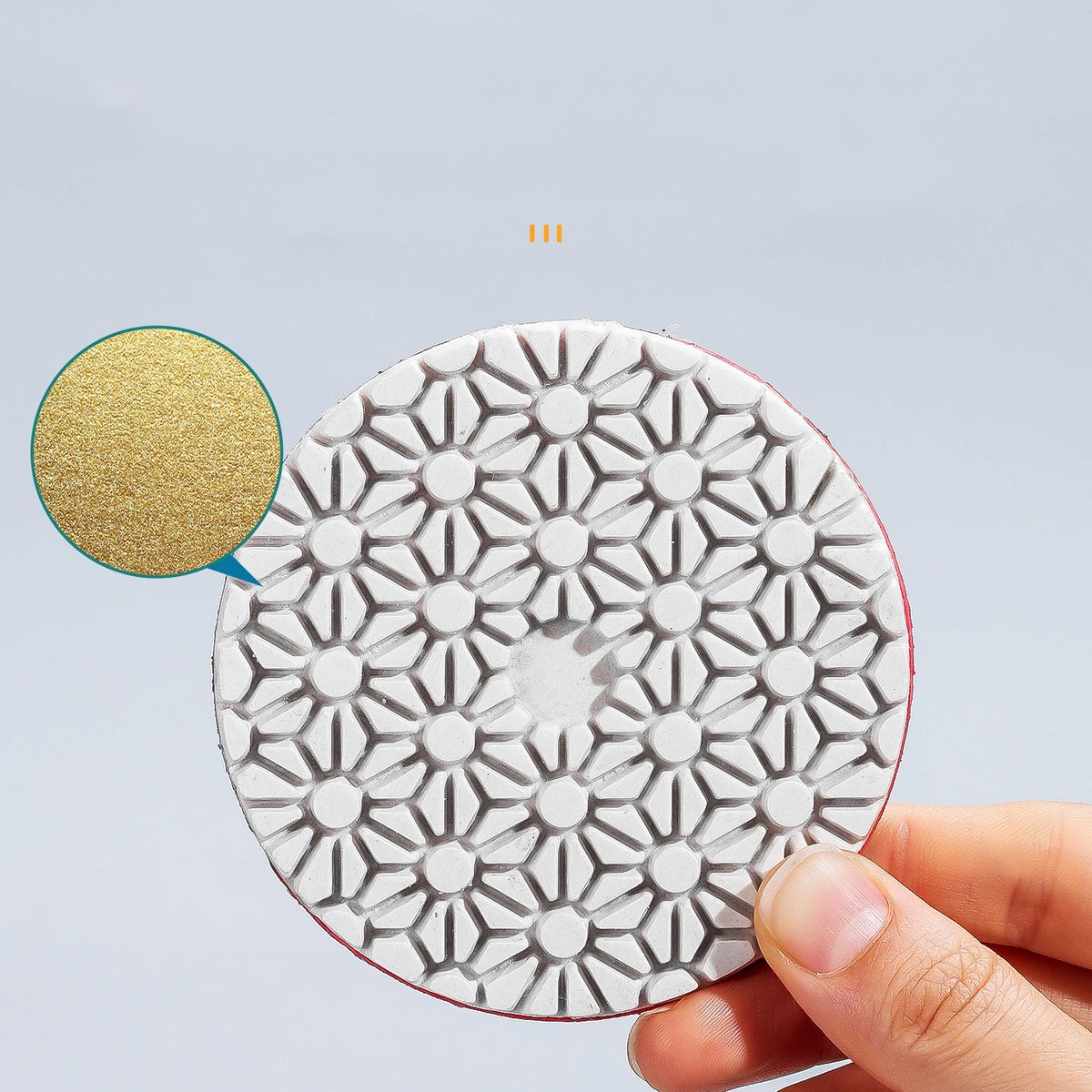 A hand holds an integrated stone trimming polishing disc set with a white and gray geometric pattern.