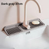 Dark gray foldable silicone sink splash mat with a faucet and soap dish installed in a white sink.