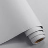 A roll of waterproof vinyl wall decals lying on a gray surface.