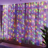 Guirnaldas de luces LED moradas y rosas con luces de hadas de colores iluminando una ventana.