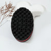Tête de brosse pour cheveux bouclés en silicone noir fixée à une base en plastique blanc.