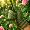 A hand wearing green gardening gloves is shown holding a thorny stem amidst pink roses and green foliage.