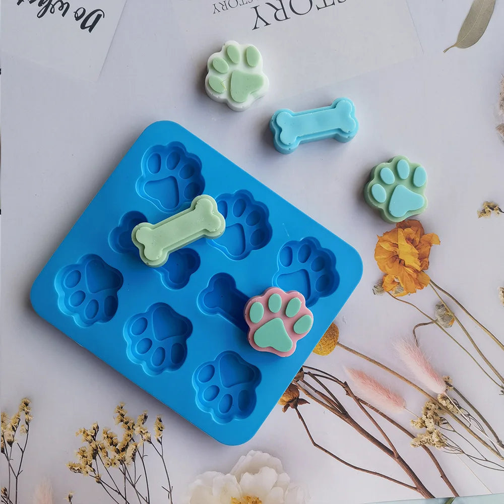 Ensemble de moules à pâtisserie en silicone bleu avec diverses empreintes de chiens en dessin vert et rose.
