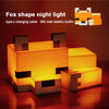 An orange fox shape night light made of LED blocks, illuminated on a wooden surface.