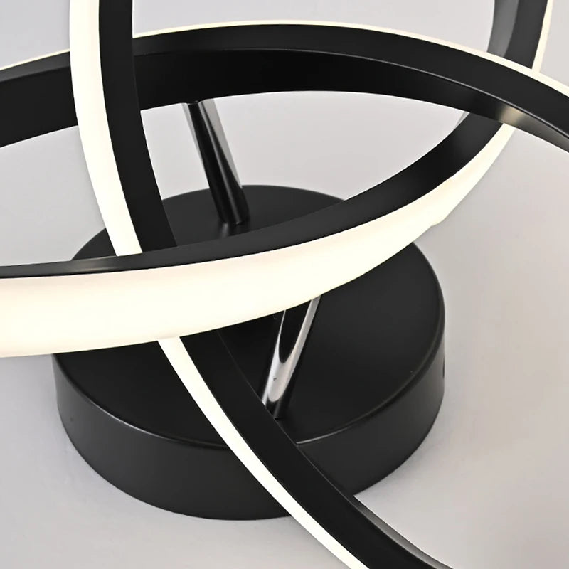 A modern black LED ceiling light fixture with a curved white light element and a touch switch.