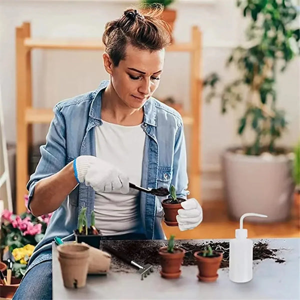 Eine Frau benutzt ein Set aus verschiedenen Gartenwerkzeugen, um kleine Sukkulenten und Bonsai zu pflegen.
