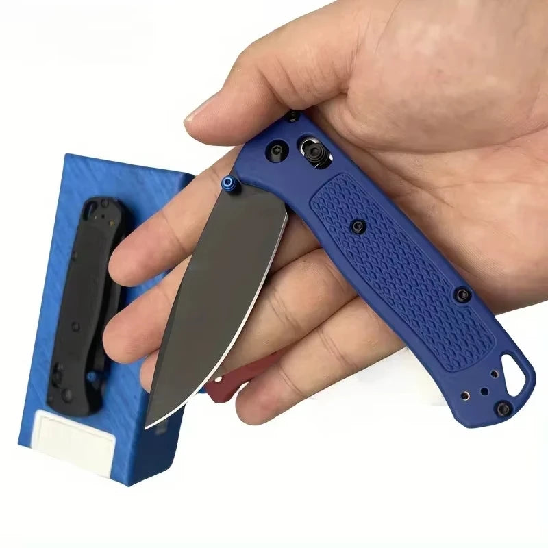 Une main tient un couteau à pliage bleu foncé avec une poignée noire et une lame argentée.