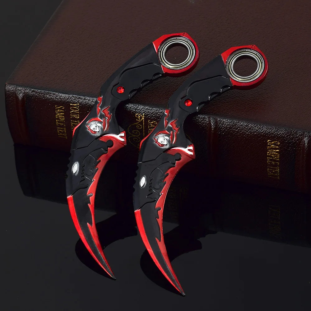 Ein Paar schwarze Drachenklaue-Modellmesser mit roten Akzenten auf einem dunkelbraunen Buch.