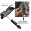 A brake pad measuring tool with a black handle and white scale used to measure the thickness of brake pads.