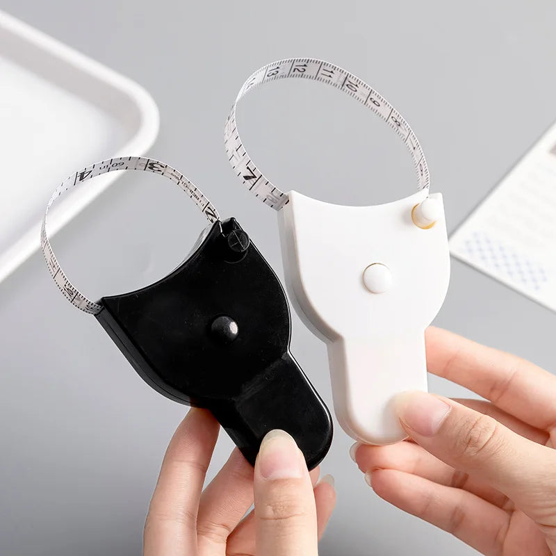 A hand holds a portable telescopic health tape measure with a torch and a measuring tape around a white object.