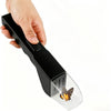 A hand holds a black handheld insect trap with a clear plastic collection chamber.