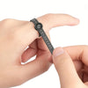 A hand is holding a black reusable ring sizer with a magnifier, showing the scale markings.