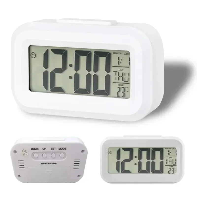 Reloj de alarma digital LED blanco con visualización de las 12:00 y un accesorio.
