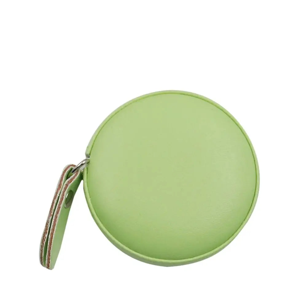 A light green retractable dual scale measuring tape with a leather strap.