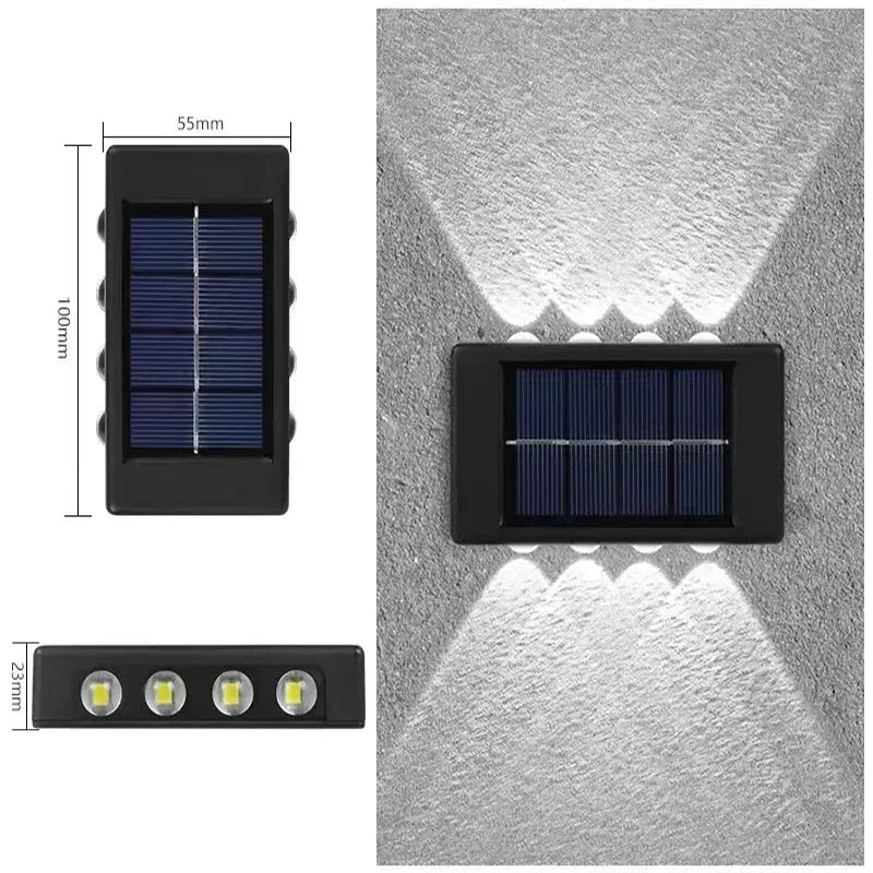A rectangular solar wall light with a black housing and multiple solar panels mounted on a gray textured surface.