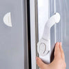 A hand is using a silicone safety clip to open a door or drawer.