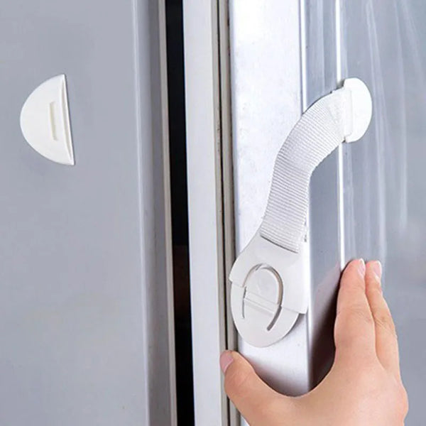 Une main utilise un clip de sécurité en silicone pour ouvrir une porte ou un tiroir.