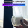 A hand holds a roll of clear window and door gap sealing tape against a dark window frame.