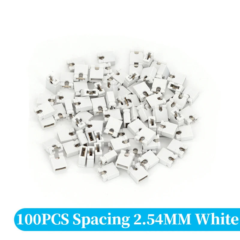 A pile of 100 white spacing jumper cap connectors for through hole applications.