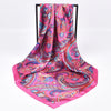 Foulard hijab en satin de soie rose vif avec des motifs paisley et floraux complexes.