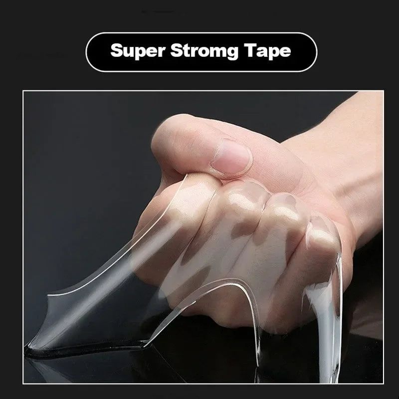 A hand is applying clear, flexible double-sided mounting tape to a surface.