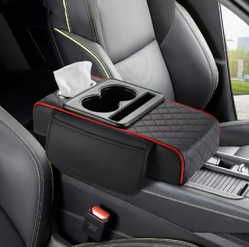 A black car armrest cushion with cup holders and a tissue is shown in a vehicle interior.