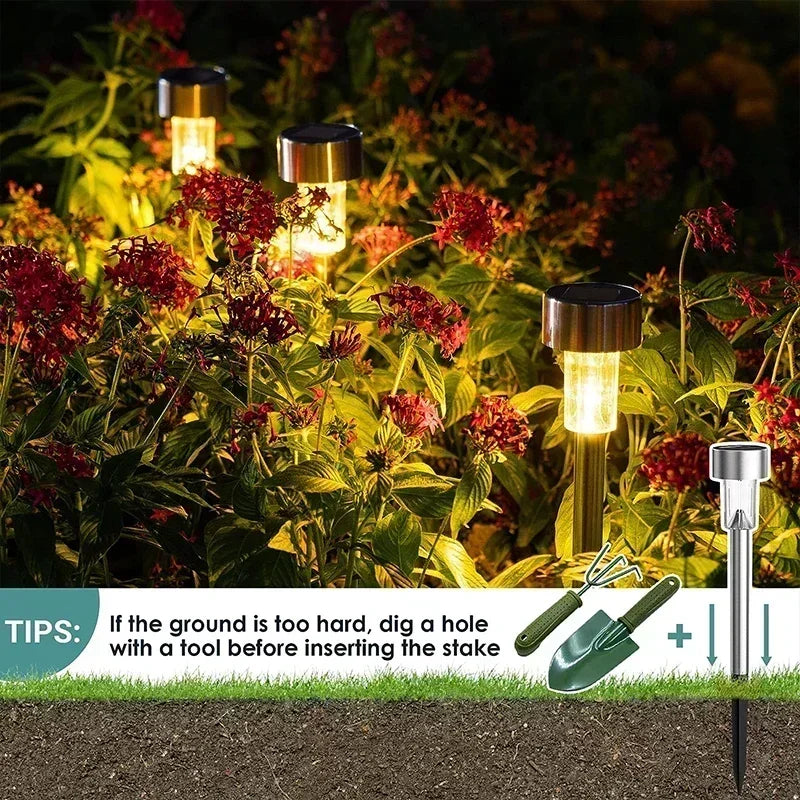 Solar powered outdoor pathway lights illuminating red foliage in a garden setting.