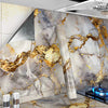 A wall covered in self-adhesive golden marble decor film featuring marbled gray and white stone patterns.