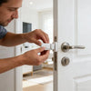A man installs a No-Drill Snap-On Door Lock for Children on a white door frame.
