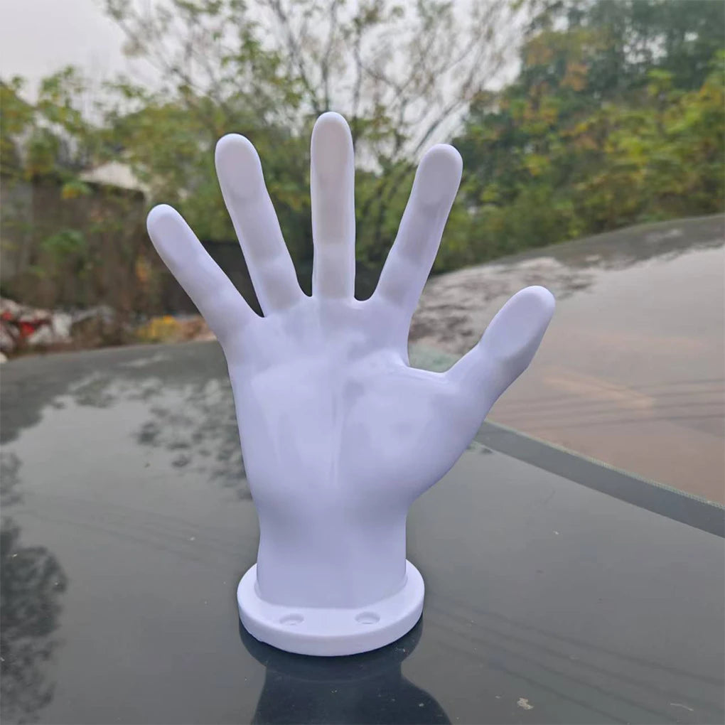 A white hand-shaped wall decor for basketball and football enthusiasts placed on a dark surface.