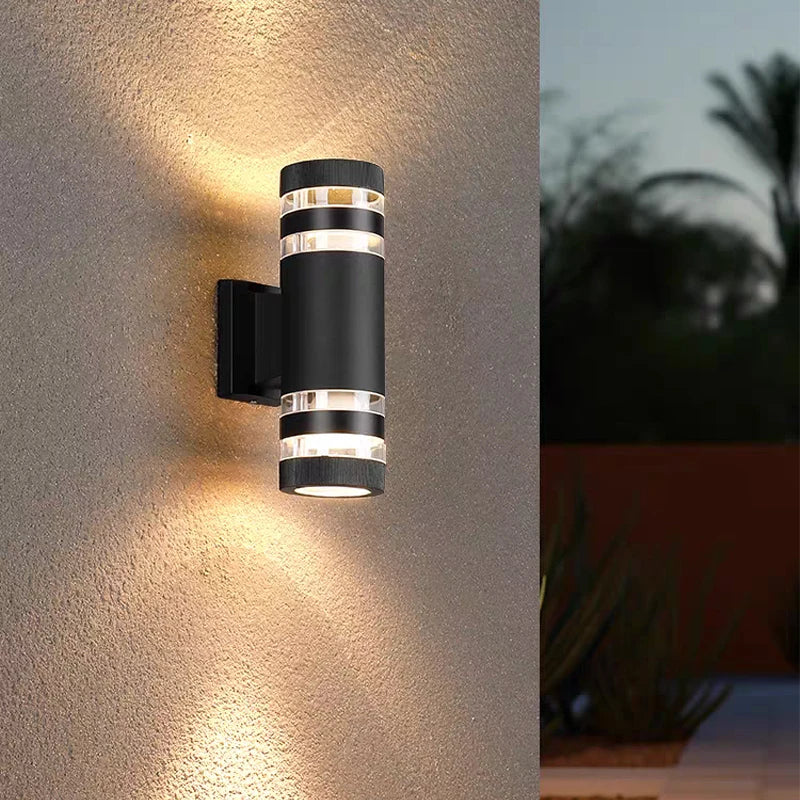 Moderne schwarze LED-Wandleuchte mit drei gestapelten runden Lichtern beleuchtet eine strukturierte Wand.