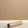 A roll of light wood-toned 3D wooden grid wall stickers placed on a light wooden floor.