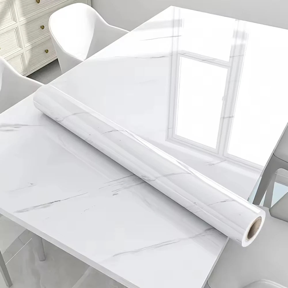 A roll of white marble self-adhesive contact paper lying on a white marble tabletop.
