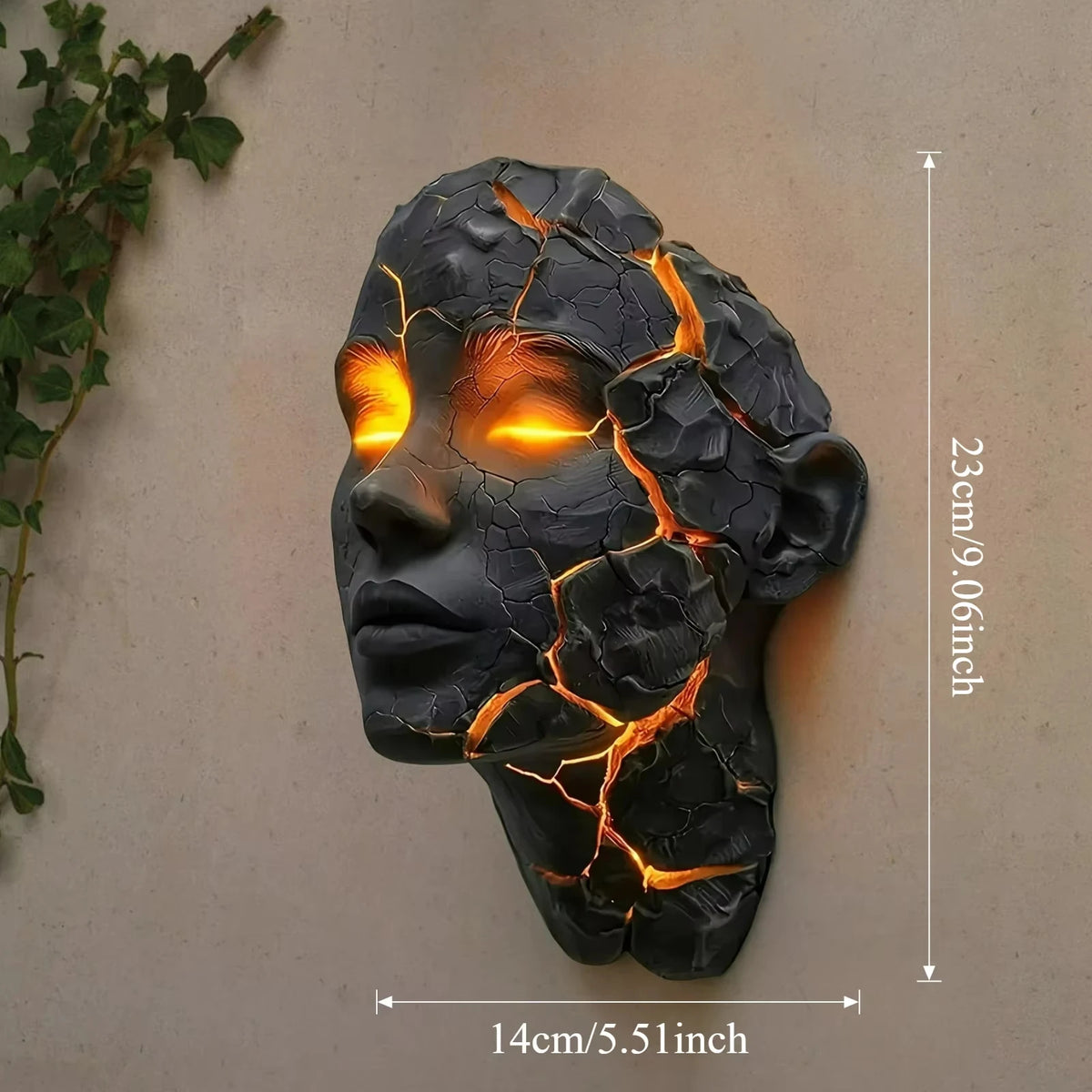 A dark resin sculpture of a cracked human head with glowing orange lines, mounted on a light beige wall.