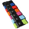 A set of black adjustable luggage straps in various colors including blue, red, orange, and pink.
