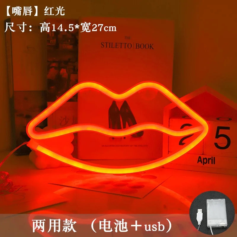 An orange neon heart lip light decoration is displayed on a red surface next to a book.