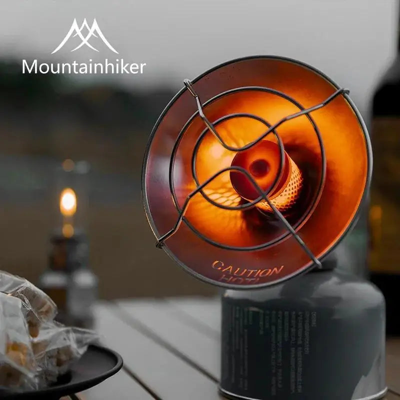 A close-up view of a portable butane camping stove with an orange burner, set on a wooden surface.