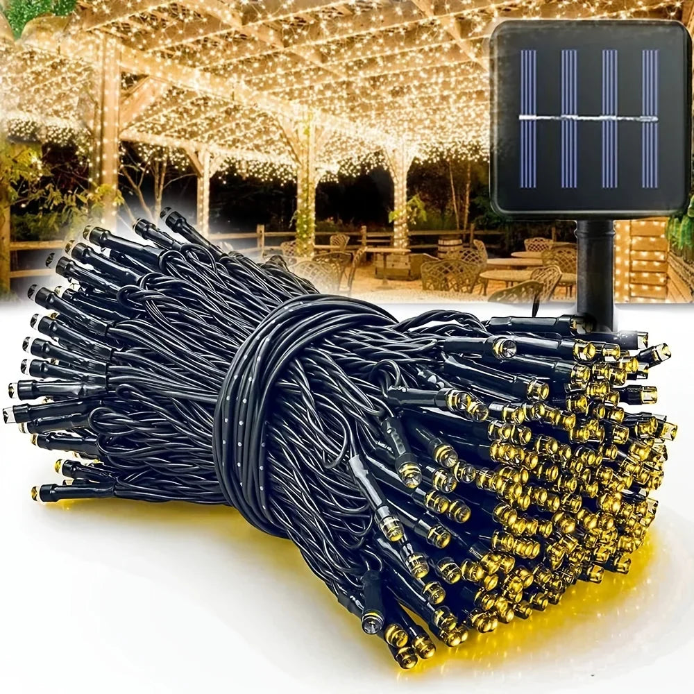 A bundle of black and gold solar powered outdoor LED string lights with wires, displayed in natural light.