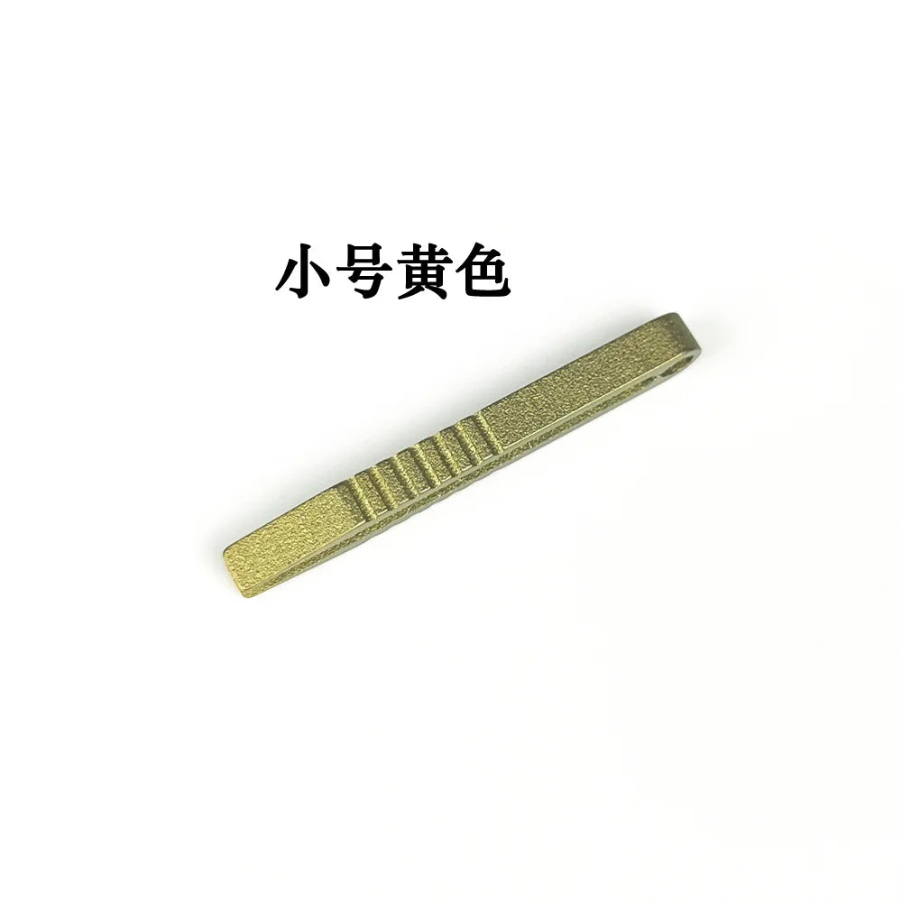 A close-up view of a small gold-colored titanium clip or tweezers.