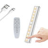 A wireless under cabinet LED light bar is shown with its remote control and a hand activating the light.