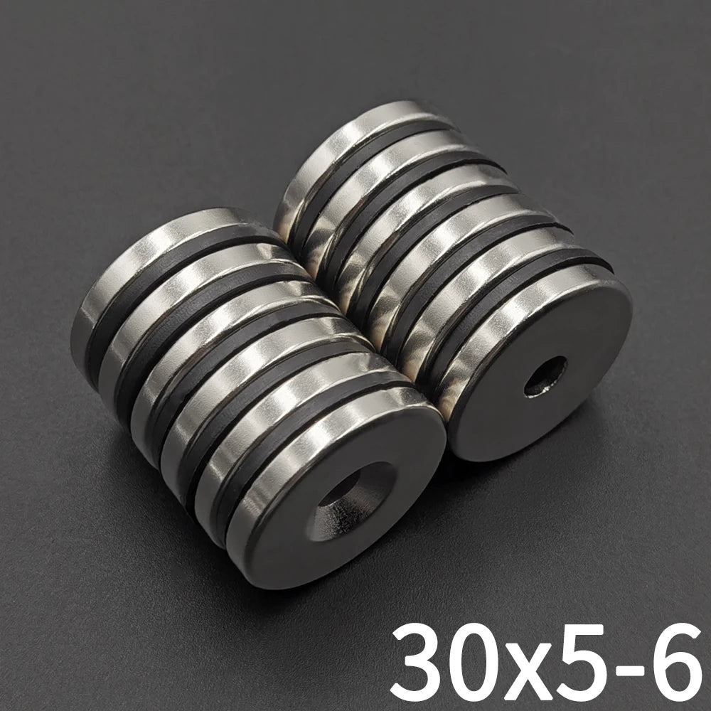 Three precision disc countersunk hole magnets with a 30x5mm size shown on a dark surface.