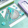 A set of seven geometry tools including a compass, ruler, and protractor laid out on a green surface.