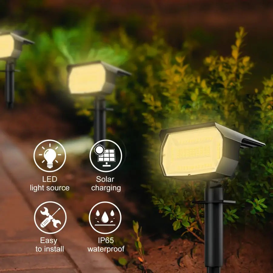 A close-up of an LED solar landscape spotlight mounted on a pole, illuminating greenery.