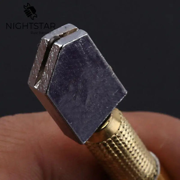 A close-up view of a precision ceramic tile glass cutter hand tool with a silver and gold finish being held by a hand.