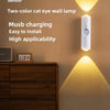 A white wall lamp with a cat eye design illuminates a wooden cabinet.