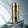 A gold-colored mini electric shaver for men is shown splashing water.
