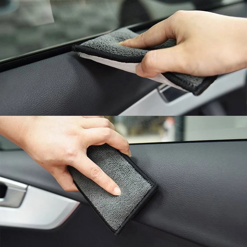 A hand is using a black microfiber detailing sponge to clean the interior surface of a car door panel.