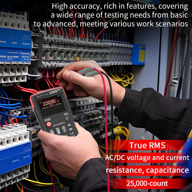 Eine Hand hält ein digitales Wärmebildgerät und ein Multimeter, um elektrische Verbindungen in einer Verkabelung zu testen.