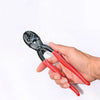 A hand holds a black heavy-duty bolt cutter with red handles and visible spring and notch features.